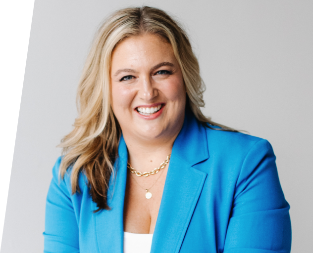 Portrait of a smiling woman with blonde hair wearing a blue blazer and gold necklace.